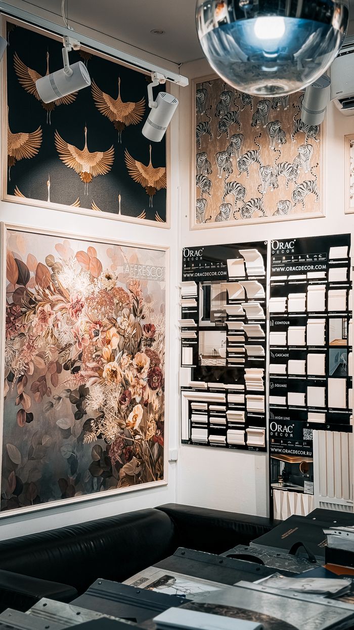 Artistic wall panels and decor in an interior design store, featuring floral and animal prints.